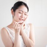 ほほを押さえた女性